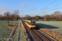An der Nebelgrenze  Für den 29. Dezember 2025 war nochmals tolles Wetter vorhergesagt. Ein möglicher Gamestopper hätte der Nebel in der Rheinebene sein können, den wir morgens jedoch noch nicht ausmachen konnten. Nach unseren ersten Aufnahmen bei Odenheim fuhren Frank und ich weiter Richtung Ubstadt. Da war er dann doch! Stettfeld (Baden) stand an jenem Tag als nächstes auf der Liste, und glücklicherweise konnten wir - wenn auch nur knapp - weiterhin mit Sonnenschein rechnen. 450 835 war als DRS 85220 Ubstadt Ort – Odenheim im Kraichgau unterwegs und konnte unter Zeitdruck mit dem Hochstativ eingefangen werden. Der Schatten der Stadtbahn ist nur bei tiefstehender Sonne möglich. Die Spuren des Raureifs waren noch sichtbar, tauten im Anschluss jedoch rasch weg.